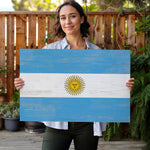 a woman holding a flag of the country of argentina