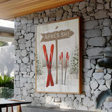 a picture of a ski lodge hangs on a stone wall