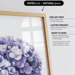 a framed print of a bouquet of purple flowers, with a natural frame.