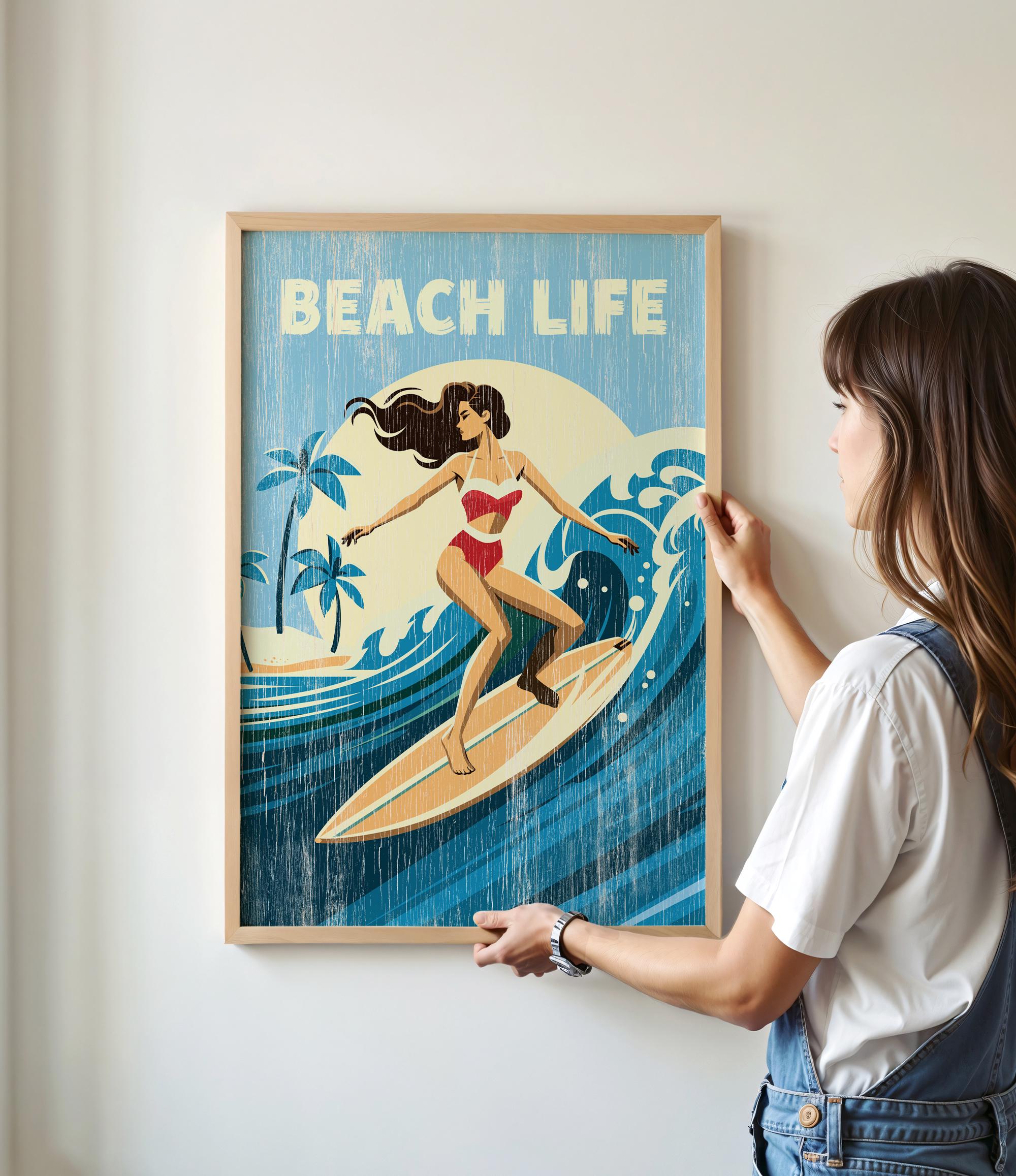 A woman is hanging a framed poster of a woman surfing on a wall.