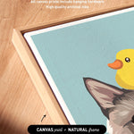 a close-up view of a framed artwork depicting a cat and a yellow duck. The artwork is framed in a natural frame, and the text indicates that the artwork wraps around the sides of the canvas, and all canvas prints include hanging hardware and high-quality archival inks.