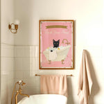 A framed poster with a black cat sitting in a bathtub, accompanied by the text "Please don't forget to wash your paws" in a pink and gold color scheme.