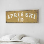 a bed with white pillows and a framed sign above it that says "APRES SKI".