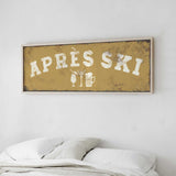 a bed with white pillows and a framed sign above it that says "APRES SKI".