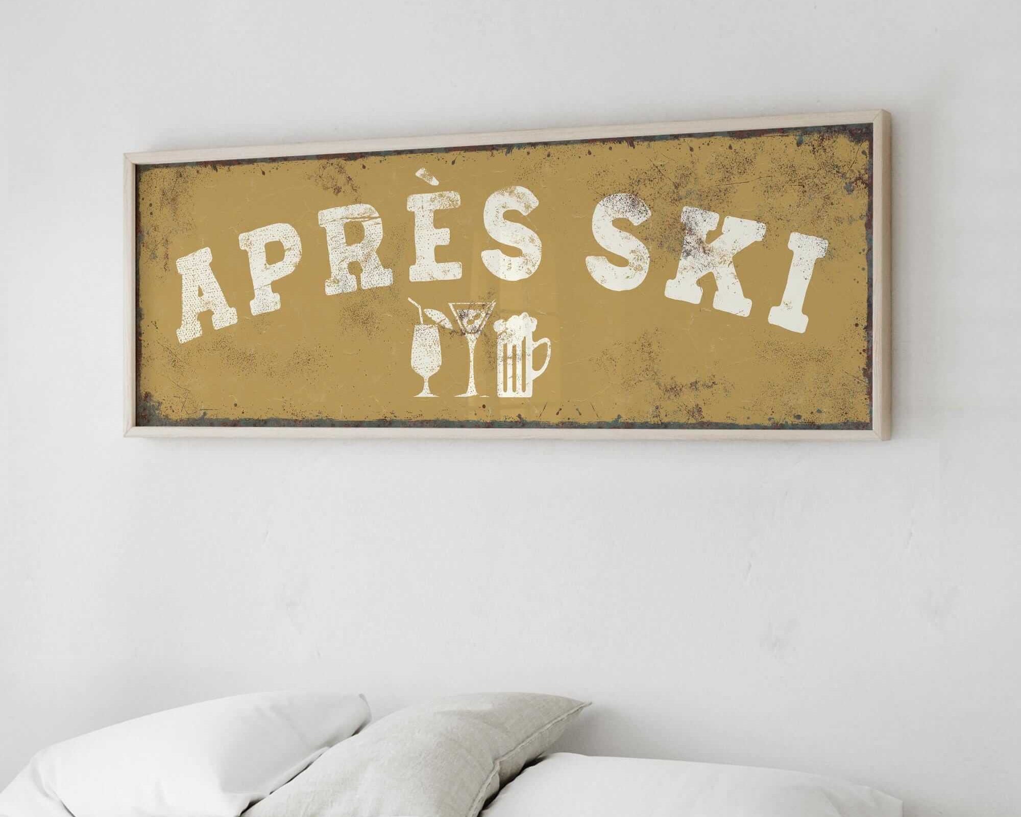 a bed with white pillows and a framed sign above it that says "APRES SKI".
