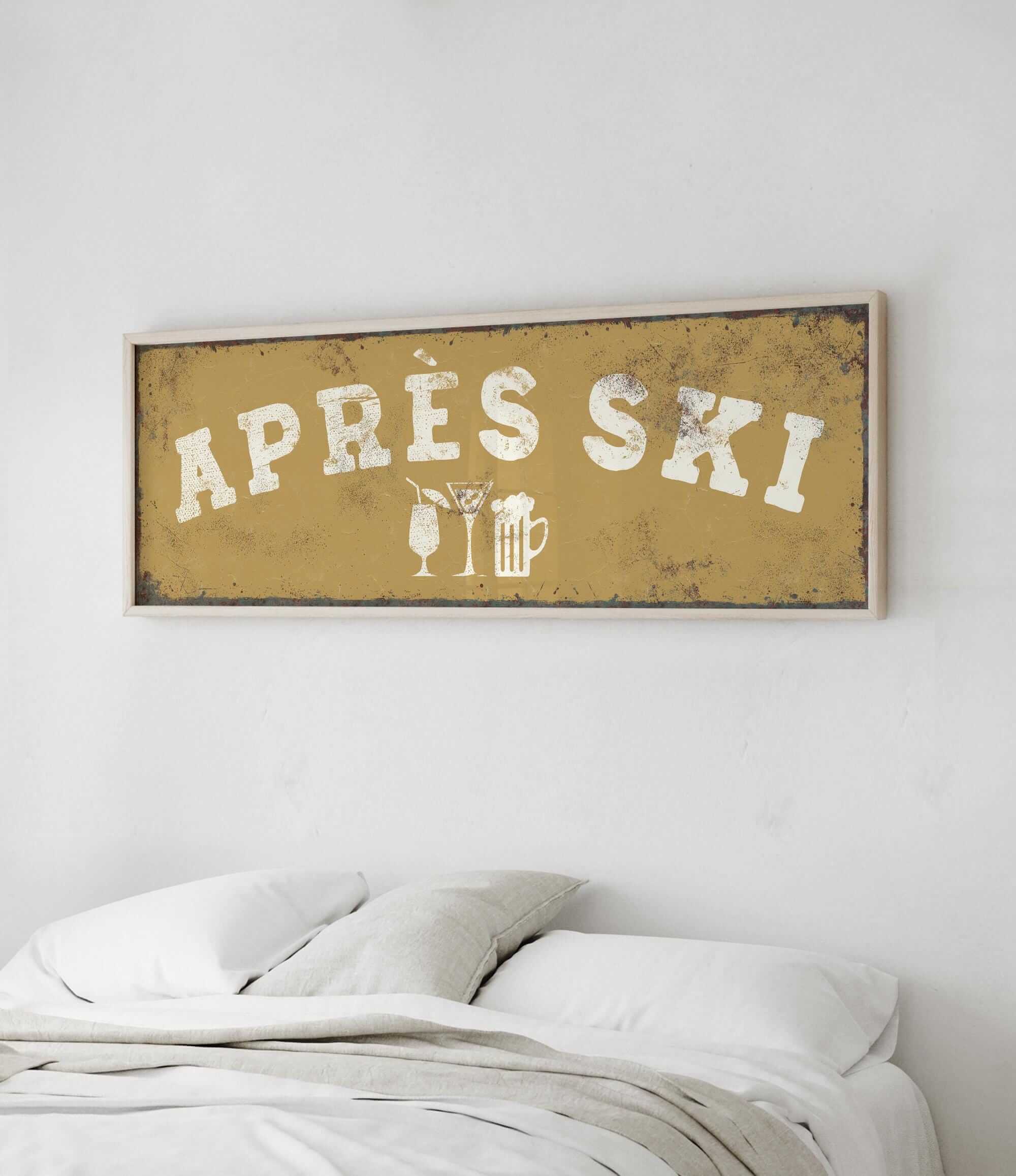 a bed with white pillows and a framed sign above it that says "APRES SKI".