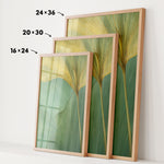 three framed prints of a leafy green plant, each with a different size and frame. The prints are arranged in a row, with the largest print on the left, the medium-sized print in the middle, and the smallest print on the right. The prints are displayed on a white wall, and there are arrows pointing to the size of each print.