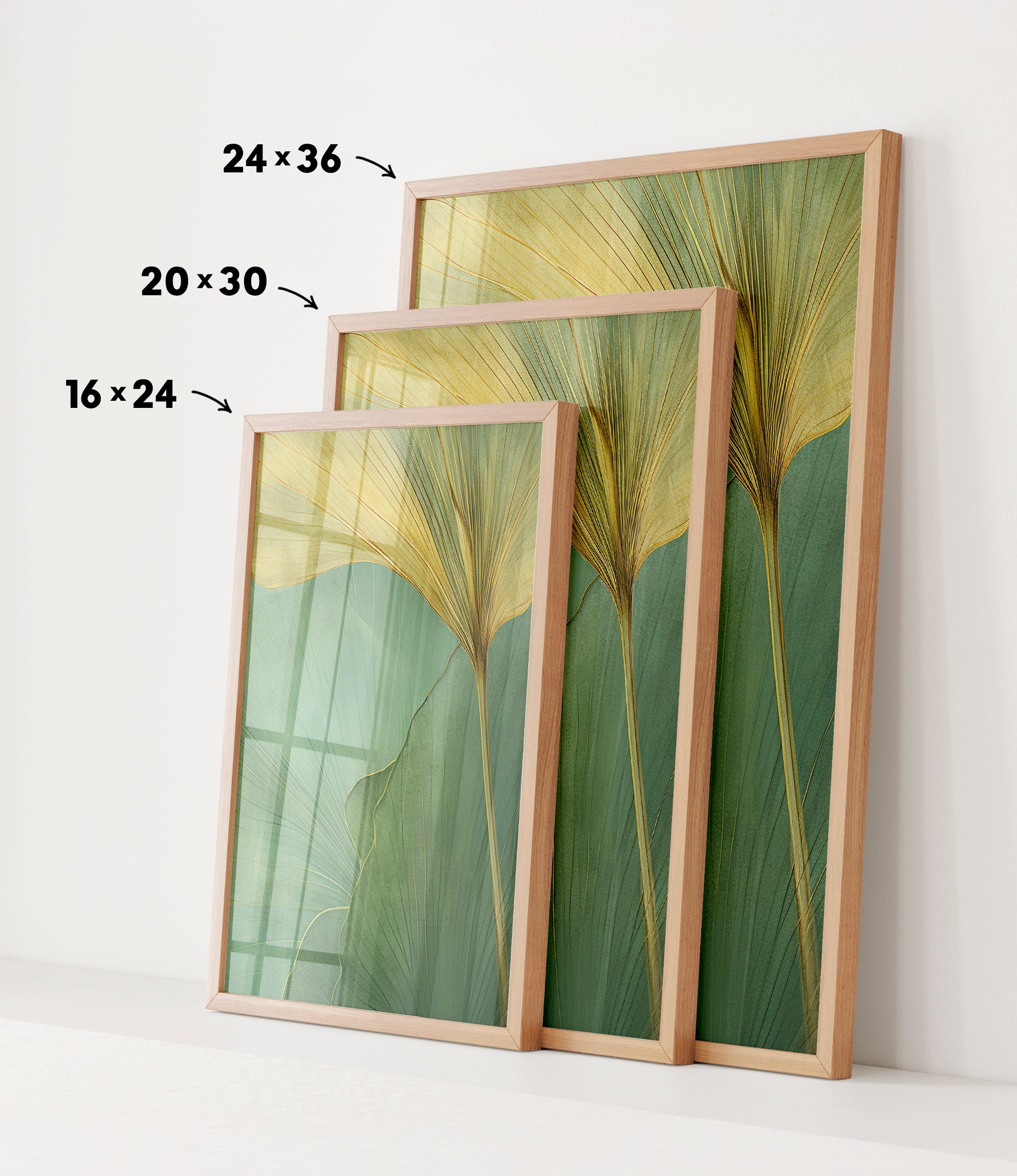 three framed prints of a leafy green plant, each with a different size and frame. The prints are arranged in a row, with the largest print on the left, the medium-sized print in the middle, and the smallest print on the right. The prints are displayed on a white wall, and there are arrows pointing to the size of each print.