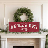 a fireplace decorated with a wreath, candles, and a red sign that says "APRés Ski".
