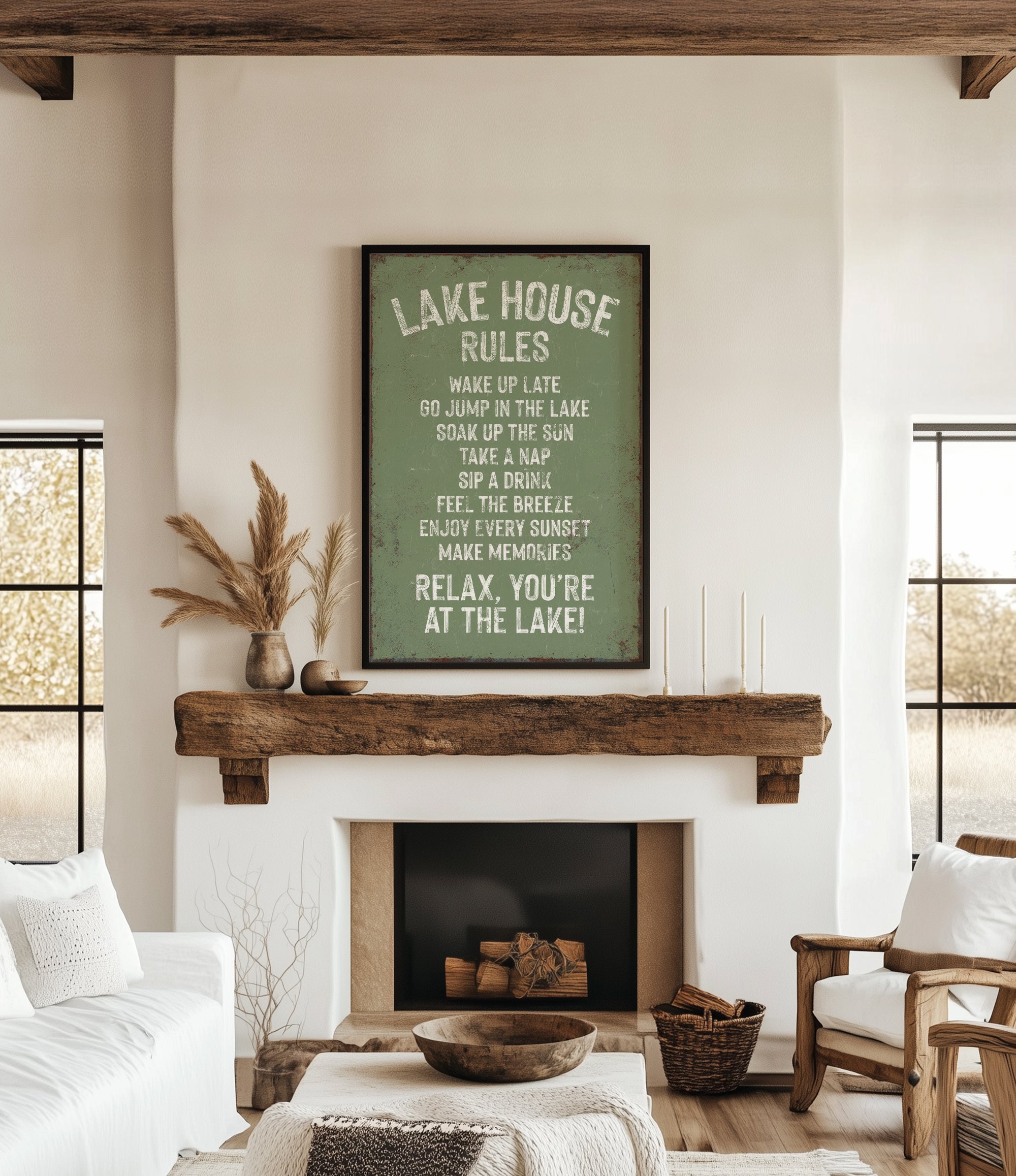 a cozy living room with a fireplace, a wooden mantel, and a framed sign that reads "Lake House Rules" above the mantel. The room has a comfortable and inviting atmosphere, with a couch, a chair, and a decorative vase on display.