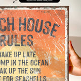 The image is a close-up of a textured, orange-colored sign with the text "ACH HOUSE RULES" written on it.