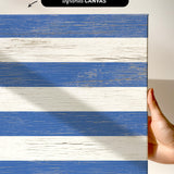 a hand holding a piece of wood with a blue and white stripe painted on it
