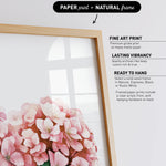 a framed print of a pink flower on a white background.