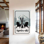 a cozy indoor setting with a fireplace, a large vase, and a framed poster of two black chairs with skis on them, along with the text "Apres-ski" (ski resort).