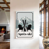 a cozy indoor setting with a fireplace, a large vase, and a framed poster of two black chairs with skis on them, along with the text "Apres-ski" (ski resort).