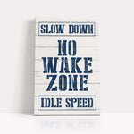 a sign that says slow down no wake zone