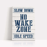 a sign that says slow down no wake zone