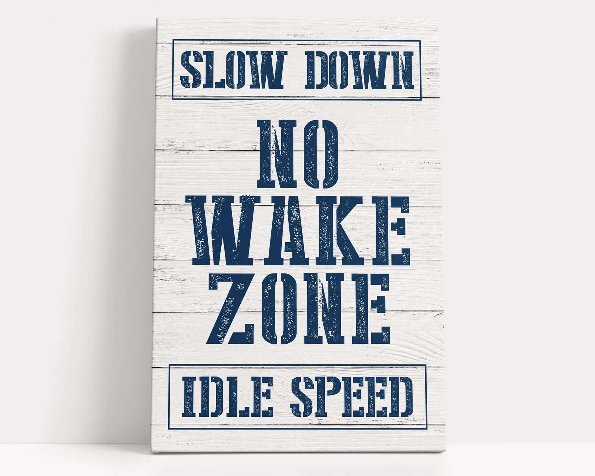 a sign that says slow down no wake zone