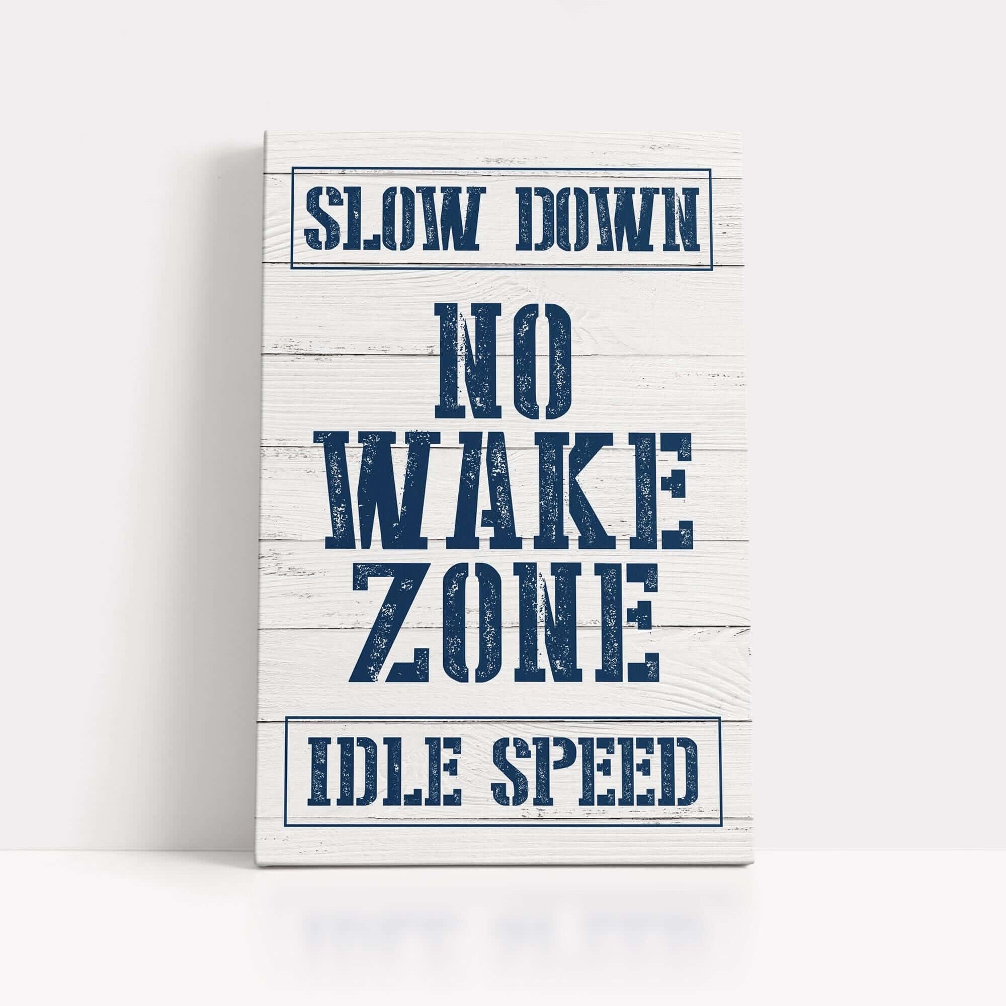 a sign that says slow down no wake zone