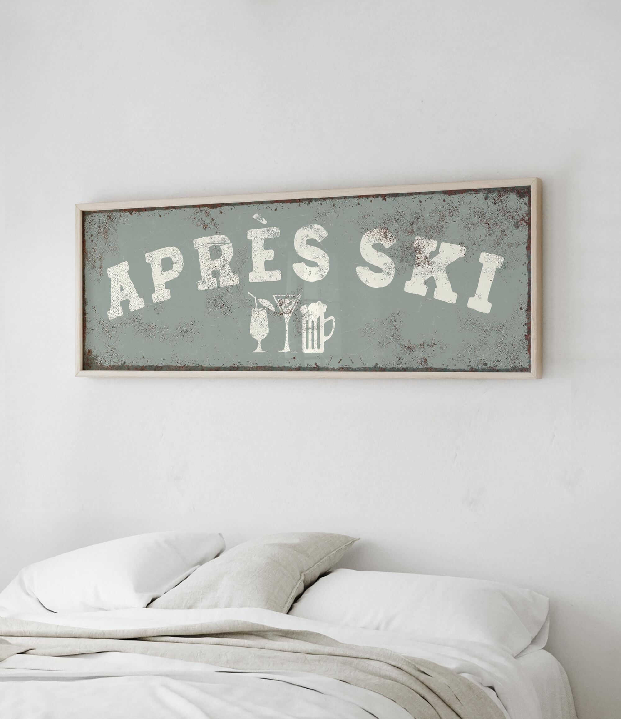 a bed with white pillows and a framed sign above it that says "APRES SKI".