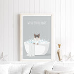 A framed poster with a cat sitting in a bathtub filled with bubbles, accompanied by the text "WASH YOUR PAWS" on a white wall.