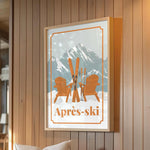 a framed poster of a ski resort with two wooden chairs and skis, set against a snowy mountain backdrop.