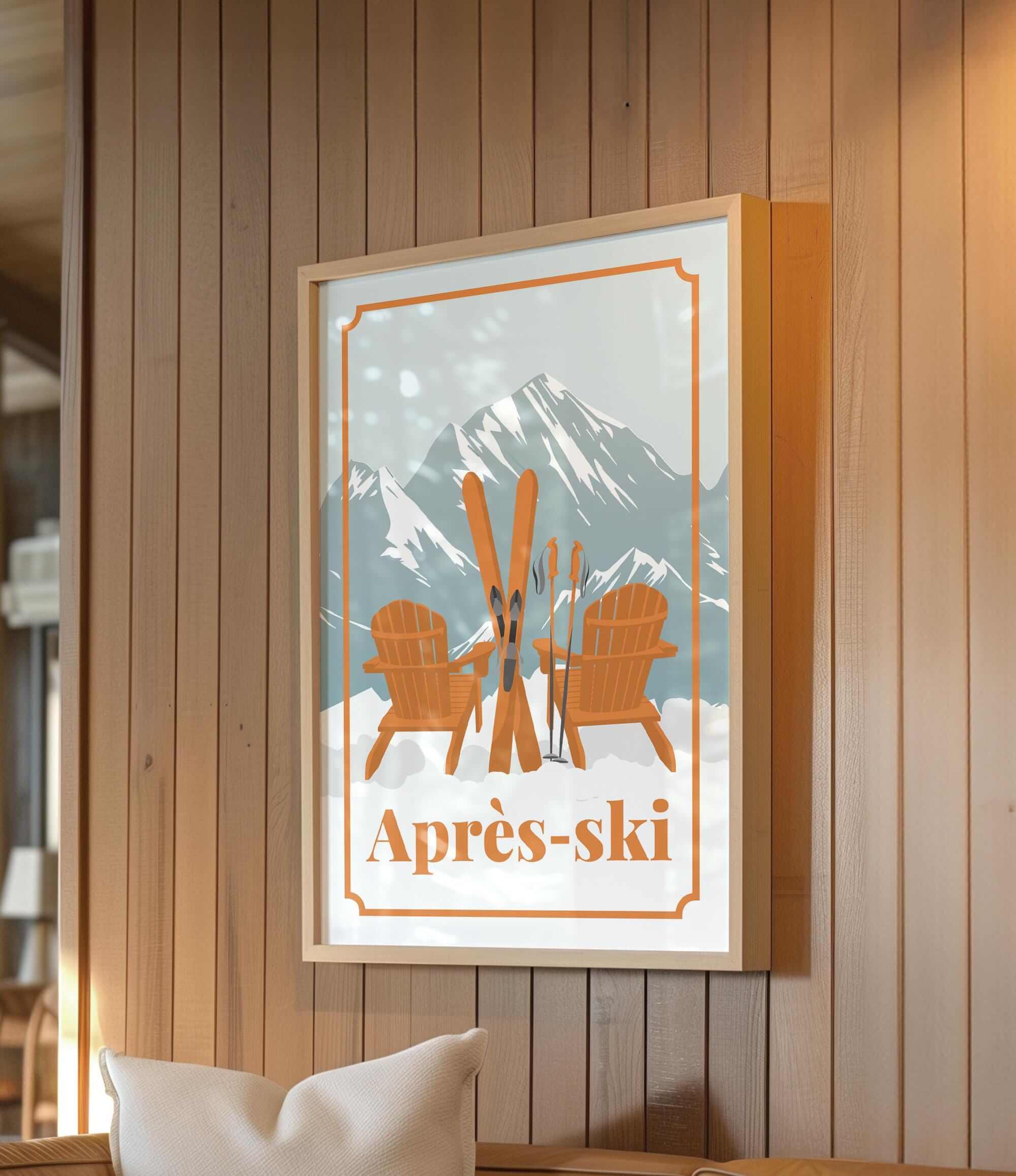 a framed poster of a ski resort with two wooden chairs and skis, set against a snowy mountain backdrop.