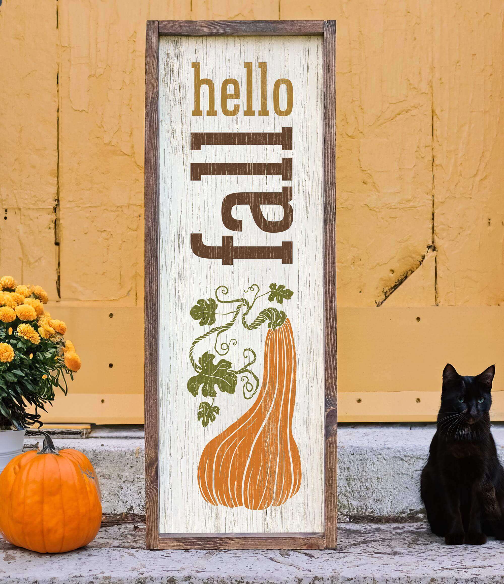a black cat sitting next to a wooden sign