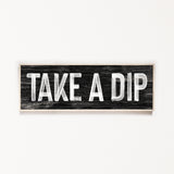 a wooden sign that says take a dip