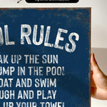 a hand holding a sign that says pool rules