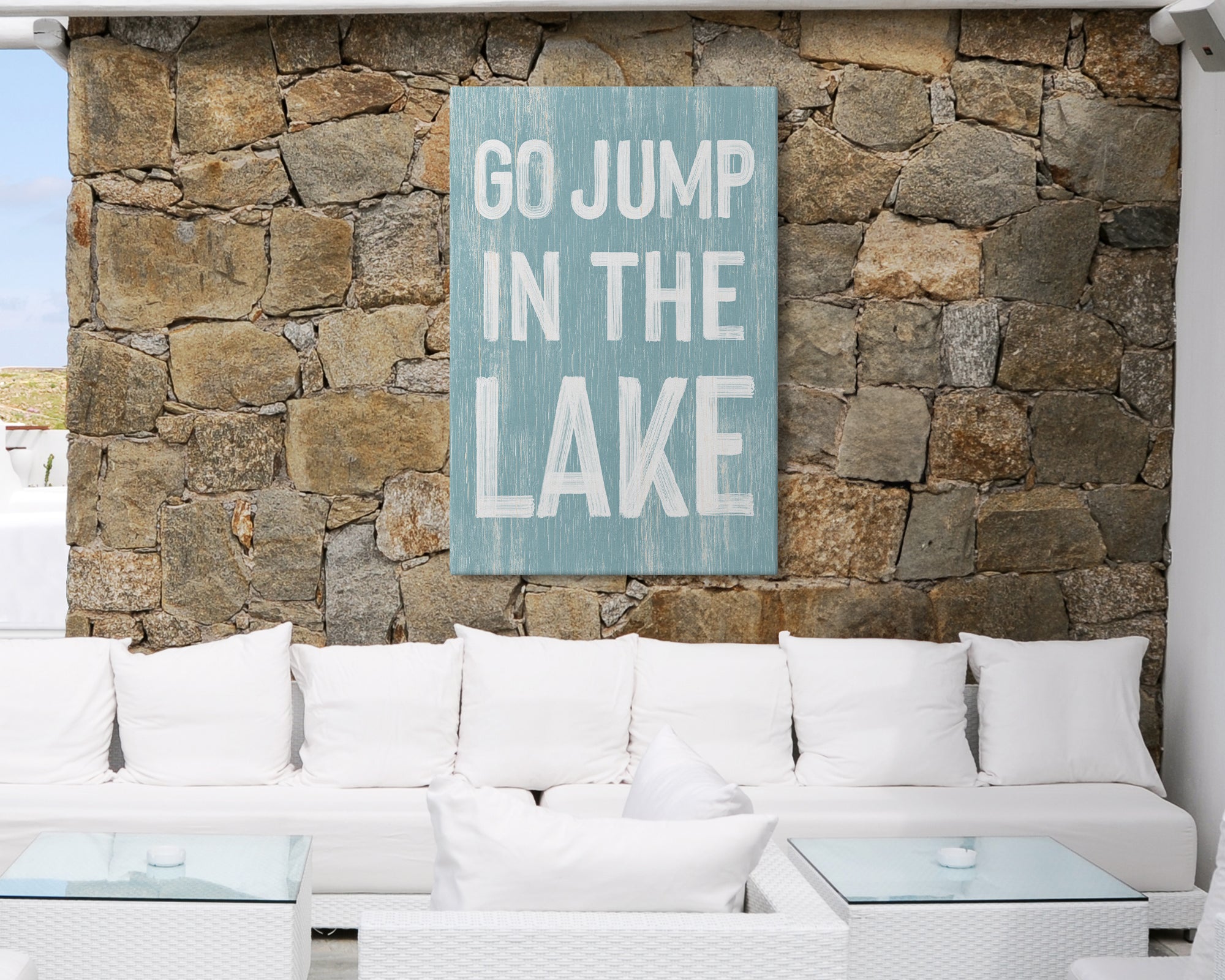 a white couch sitting in front of a stone wall