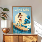a framed poster of a woman paddleboarding on a lake, with the text "LAKELIFE" prominently displayed.