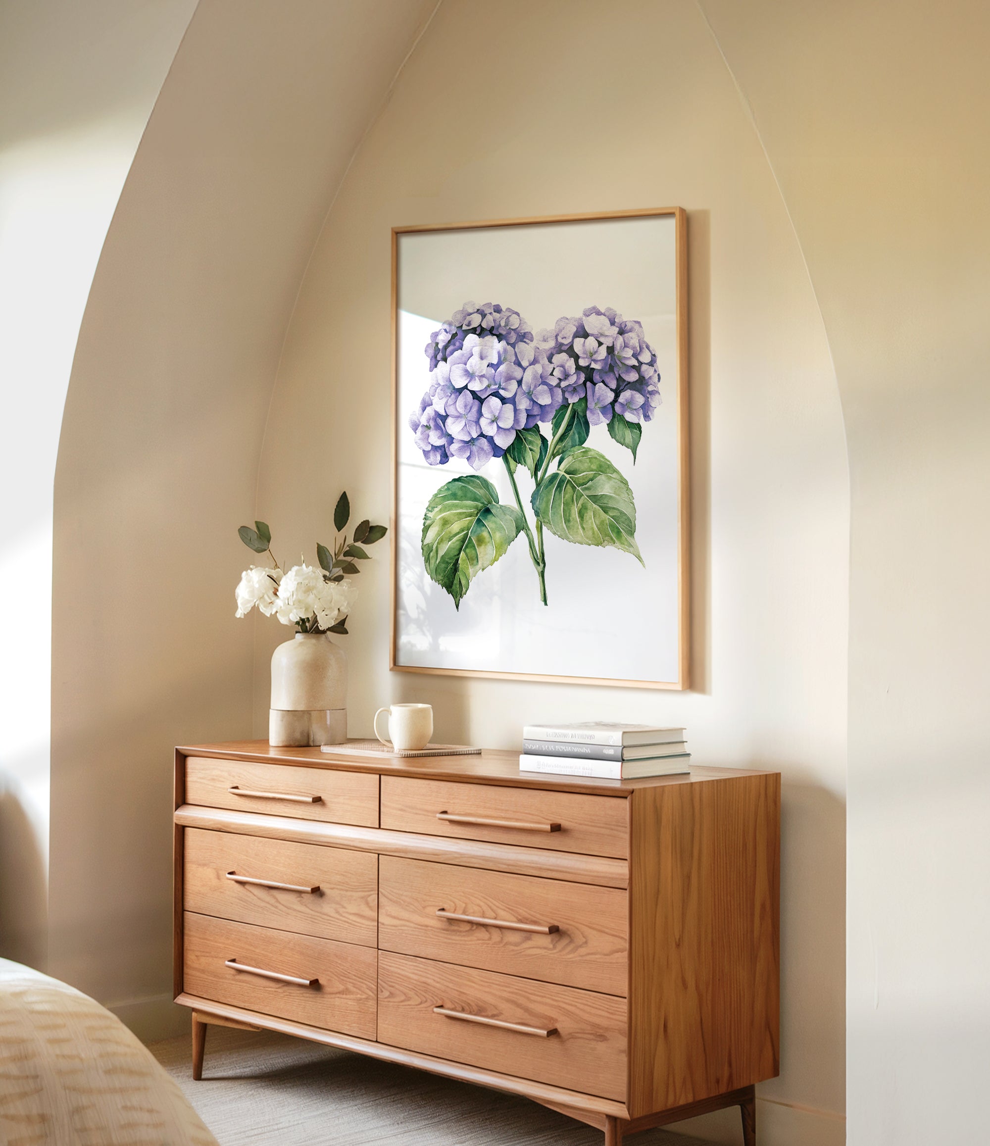 a wooden dresser with a framed painting of purple hydrangeas hanging on the wall above it. The dresser has six drawers and a vase of white flowers on top.