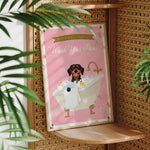 A pink sign with a dog sitting in a bathtub, surrounded by bubbles, and the text "Please don't forget to wash your paws" is displayed on a wooden shelf.