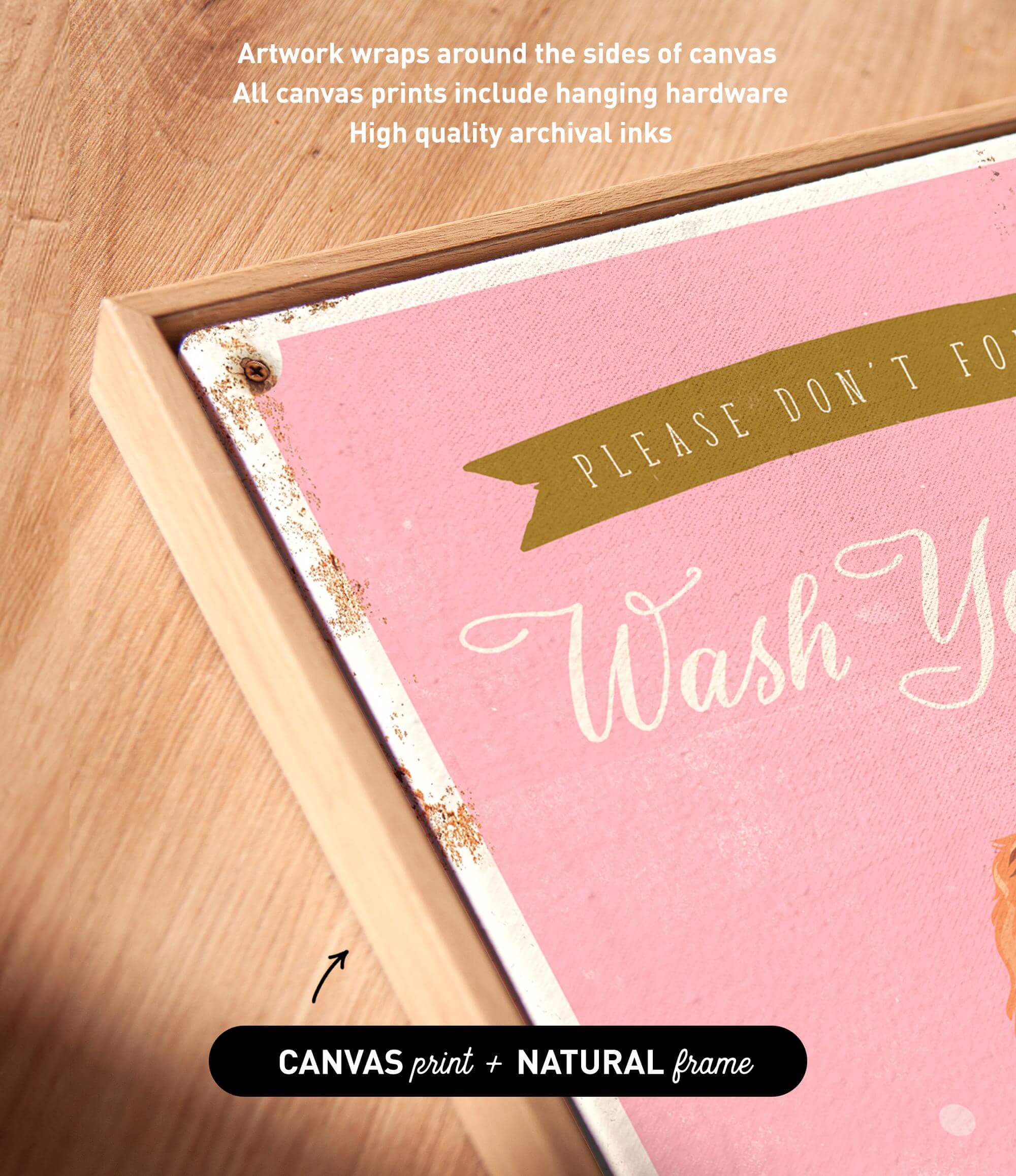 The image is a close-up of a pink canvas with the text "Please don't forget to wash your hands" written on it. The canvas is framed in a natural frame, and there is a small arrow pointing to the bottom right corner of the canvas.