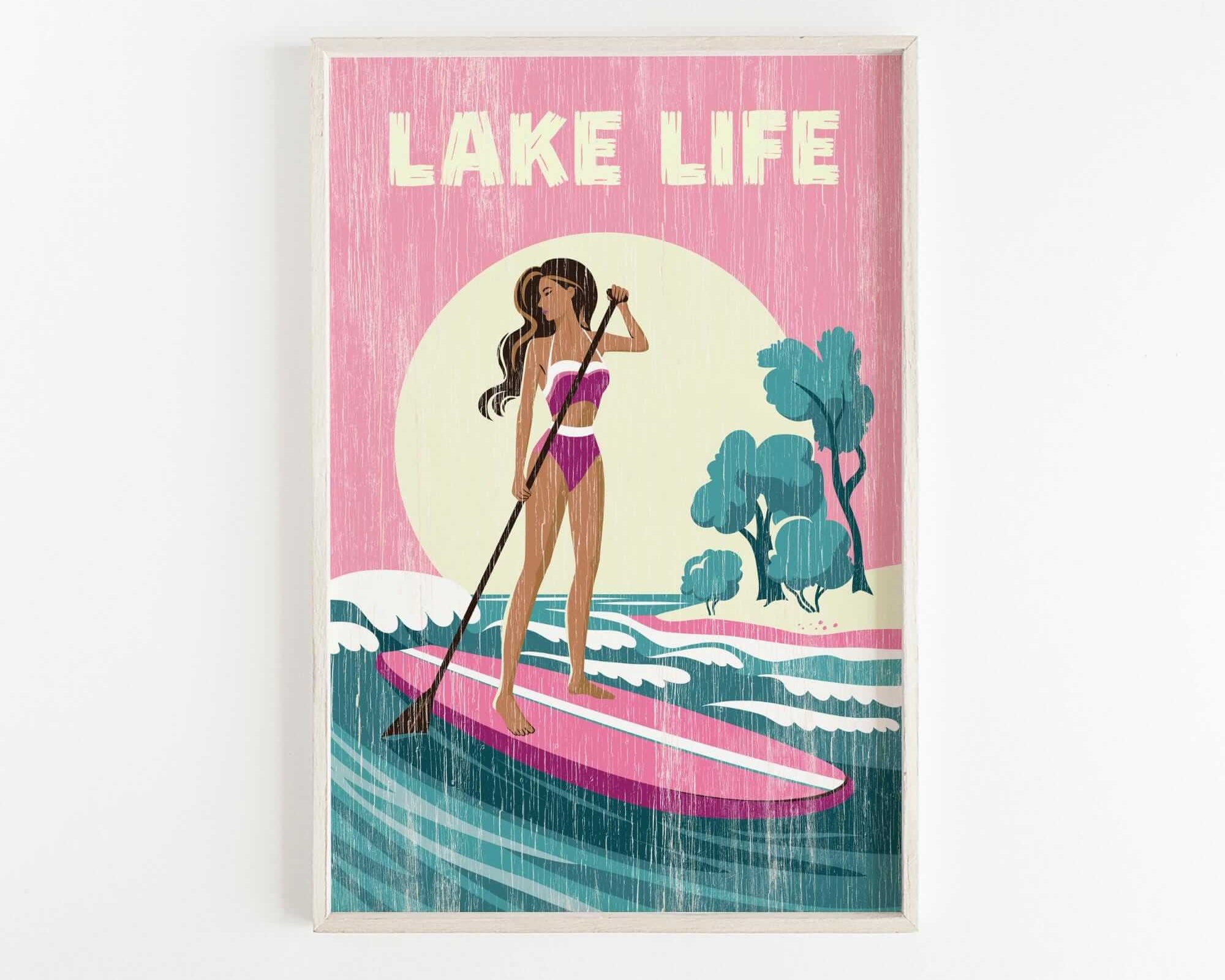 A woman in a pink swimsuit is paddleboarding on a pink surfboard, with a sunset and trees in the background.