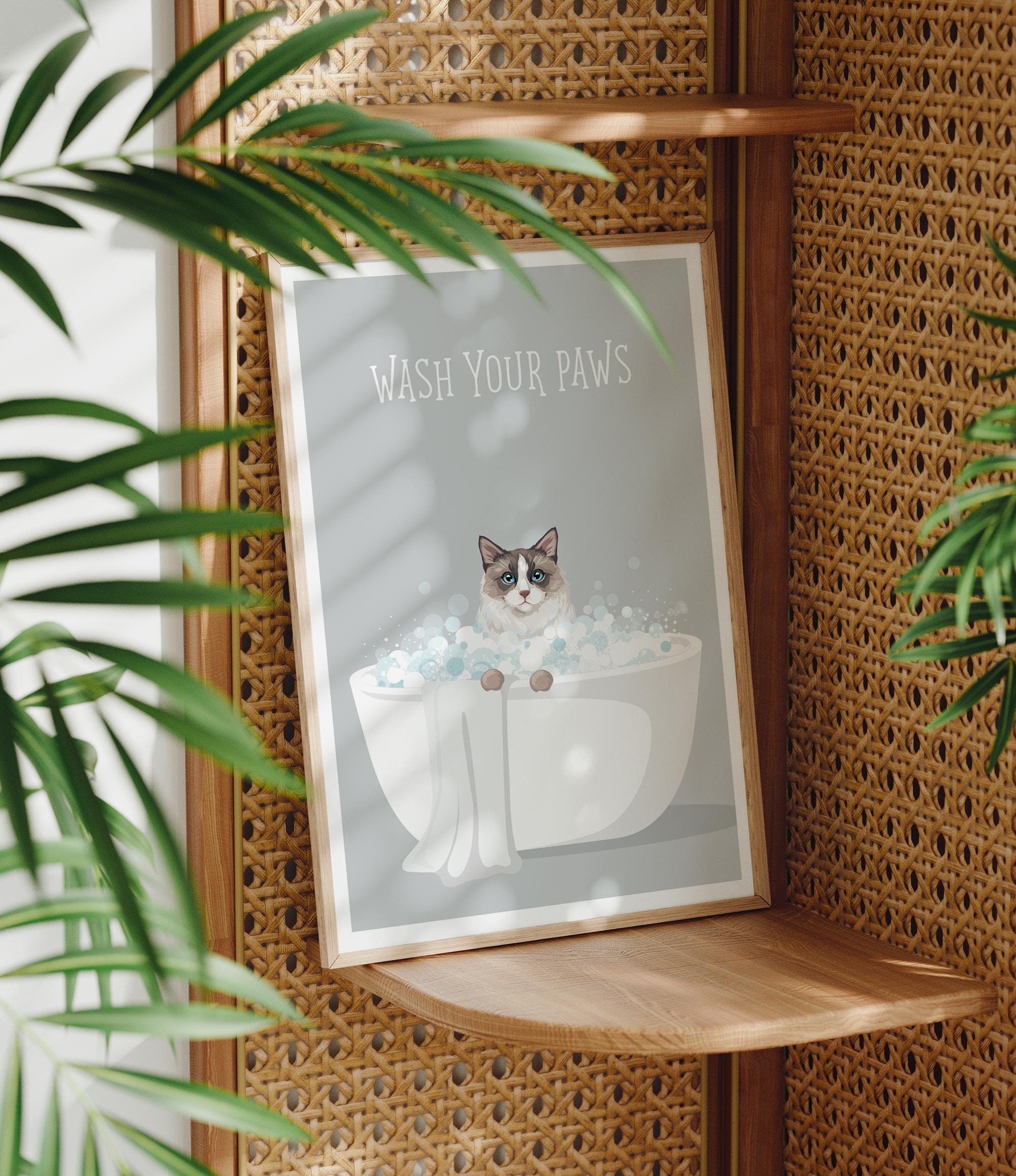 A framed poster with a cat sitting in a bathtub, surrounded by bubbles, with the text "WASH YOUR PAWS" displayed on it.