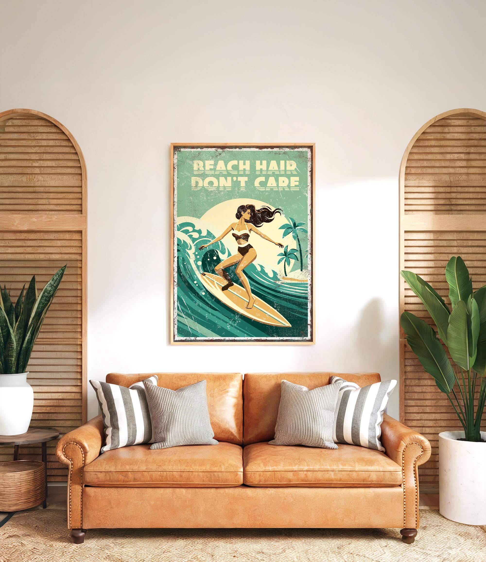 a vintage poster of a woman surfing with the text "BEACH HAIR DON'T CARE" displayed above her. The poster is hanging on a wall above a brown leather couch with striped pillows.