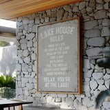 a framed sign with a list of rules for a lake house, mounted on a stone wall.
