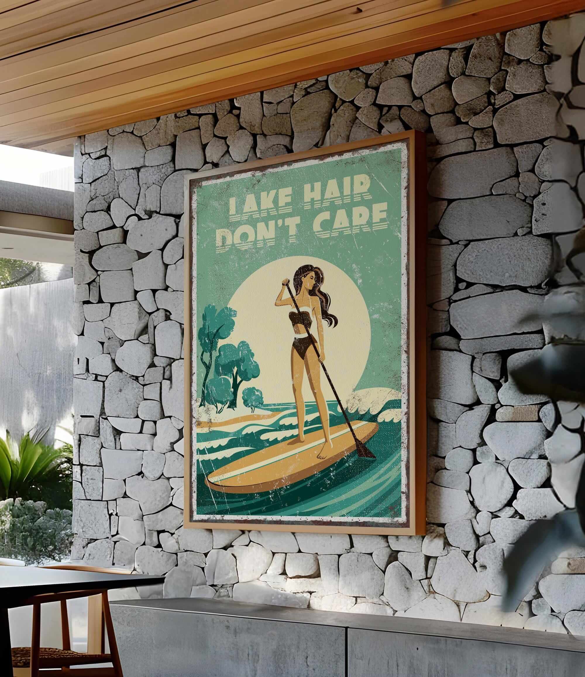 A framed poster with a woman paddleboarding on a lake, with the text "LAKE HAIR DON'T CARE" displayed prominently.