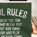 a hand holding a sign that says pool rules