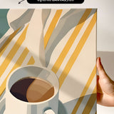 a hand holding a white mug filled with coffee, set against a background of yellow and white striped fabric.
