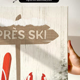 a hand holding up a sign with skis on it