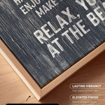 The image is a close-up of a black and white textured canvas print with a wooden frame, placed on a wooden surface.