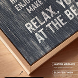 The image is a close-up of a black and white textured canvas print with a wooden frame, placed on a wooden surface.