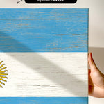 a hand holding a piece of wood with a flag painted on it
