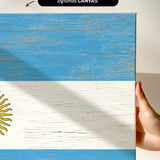 a hand holding a piece of wood with a flag painted on it
