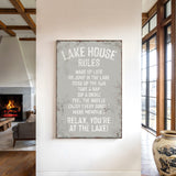 a sign that reads "LAKESHOUSE RULES" hanging on a wall in a room with a fireplace and a large window.
