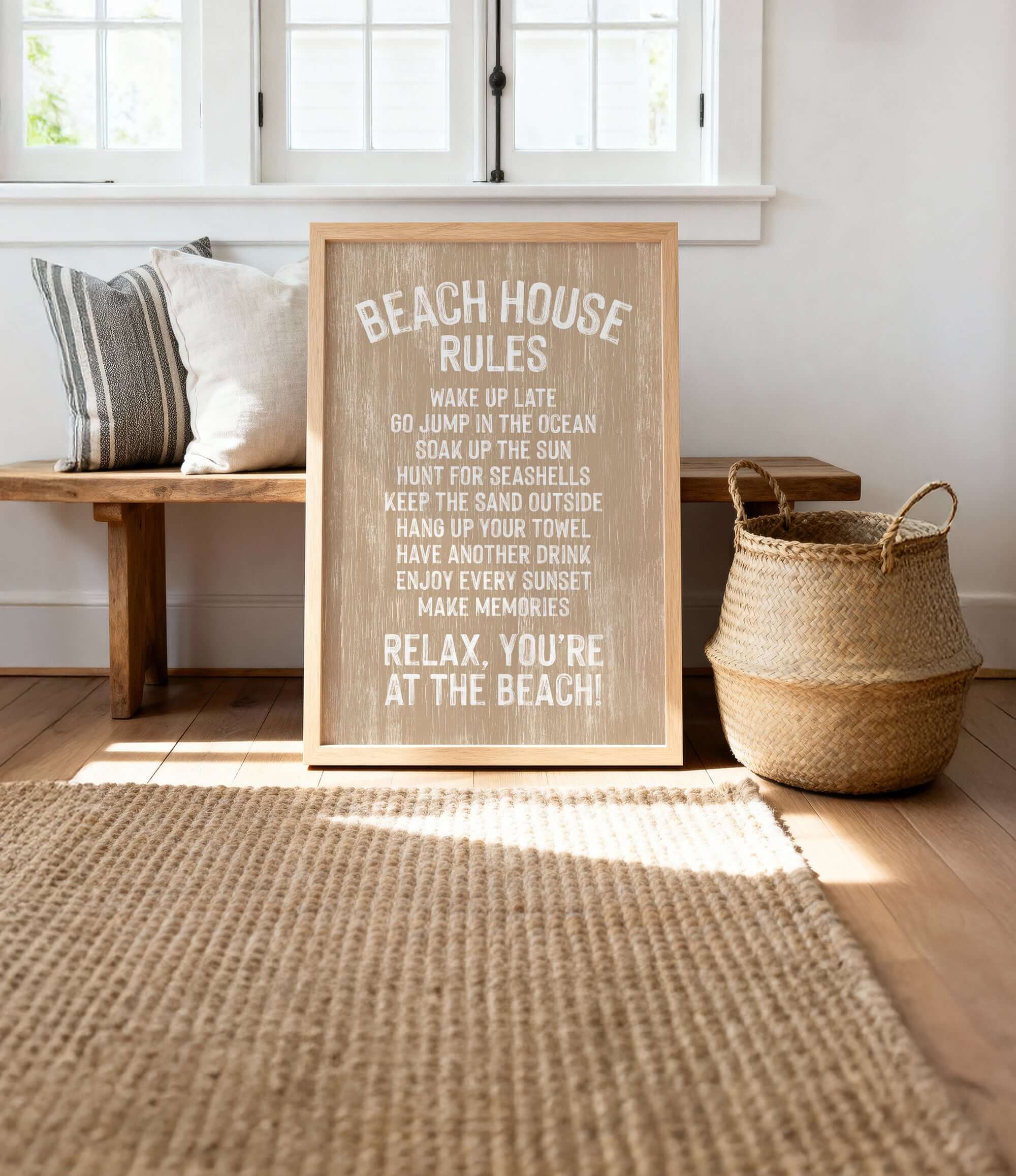 A wooden sign with white text is displayed in a room with a bench, a woven basket, and a rug.