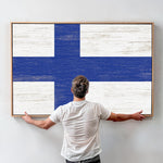 a man standing in front of a painting of a blue and white cross